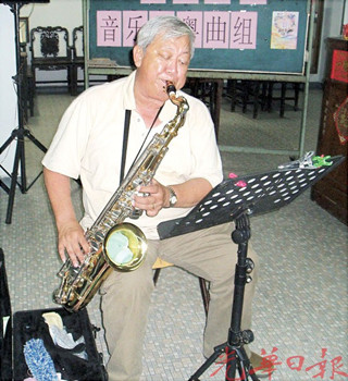 萨克斯管粤曲乐师陈振兴，投入于演奏中。（马来西亚《光华日报》）